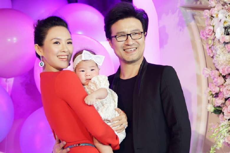 Actress Zhang Ziyi debuts her daughter at Beijing celebration.